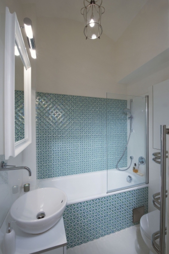 V koupelně byla zvolena skleněná mozaika, a to pouze na jedné stěně, aby prostor nebyl dekorem zahlcen. Na ostatních zdech je zcela jednoduchá bílá velkoformátová dlažba