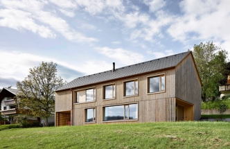 Dřevo patří ve Vorarlbersku k tradičním stavebním materiálům. Na rozdíl od mohutných trámů, z nichž se v této oblasti stavěla hospodářská stavení a salaše, zvolili architekti ze studia Innauer Matt subtilnější latě, z nichž „utkali“ plášť domu