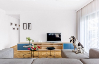 Obývací pokoj je vybavený nábytkem zhotoveným na míru podle návrhu architektky. Barevný akcent modré se sem propisuje z kuchyně a umocňuje kompaktnost celku
