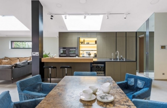 Velký jídelní stůl (2,4 x 1,2 m) na kovové podnoži zhotovený z travertinu Tabaco je vyrobený podle návrhu Jaroslava Harmáčka. Je vyhřívaný, vybavený datovými kabely a ovládáním osvětlení. Obklopují ho židle (Ikea) s područkami potažené snímatelnými povlaky ušitými ze starých jeansů, které sem navrhla paní domu