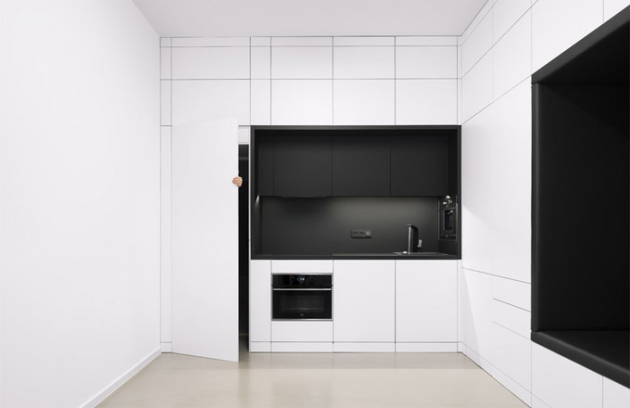 Kompaktní blok obsahuje všechny nezbytné funkce a prvky i plně vybavenou kuchyň. Pootevřené dveře naznačují průchod dál do soukromé části interiéru 