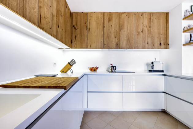 Kuchyň situovaná do tvaru písmene U poskytuje velkorysou pracovní plochu. Kapacitu úložných prostor významně rozšiřují horní skříňky vedoucí až ke stropu