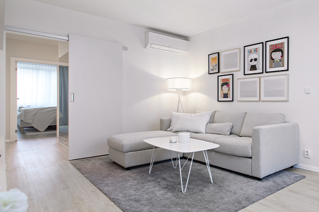 Klimatizace zvládne chlazení obývacího pokoje i kuchyně, ale je záměrně umístěna tak, aby nebyla příliš nápadná. Příjemný odpočinek zajišťuje útulný kout s kobercem a pohovkou (IKEA).
