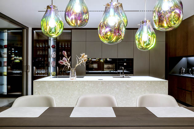 V minimalistické kompozici interiéru moderní vily nechali designéři vystoupit ušlechtilost materiálů, jako je výběrová dubová dýha, dubový masiv, kov, Corian či keramika. Souhru luxusních materiálů podtrhli promyšlenou světelnou scénou i řemeslnými detaily v podobě frézovaných dřevěných obkladů či asymetricky tvarovaných schodnic. 