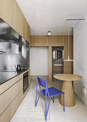 V zemitém základu kuchyně svítí židle HAY Petit Standard v elektrizujícím modrém provedení. Stůl, vyrobený na zakázku truhlářem Rastislavem Janíkem, doplňuje svítidlo Skan od značky Vibia.