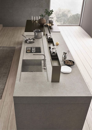 Sign, kuchyň s&nbsp;ostrůvkem z&nbsp;kompozitn&iacute;ho materi&aacute;lu na b&aacute;zi keramick&yacute;ch nanoč&aacute;stic Fenix s&nbsp;integrovanou myc&iacute; z&oacute;nou doplňuje konzola kombinuj&iacute;c&iacute; osvětlen&iacute; pracovn&iacute; plochy s&nbsp;&uacute;ložn&yacute;m prostorem 