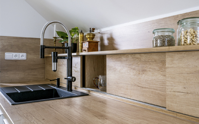 Realizace mycí zóny s filtrační baterií Vital Tap a s praktickým využitím úložného prostoru za dřezem diskrétně uzavřeným za posuvy