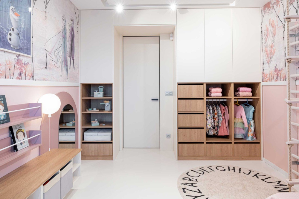 Vzdu&scaron;n&yacute; dětsk&yacute; pokoj s intuitivn&iacute;mi &uacute;ložn&yacute;mi prostory, do kter&eacute;ho barevně lad&iacute; otočn&eacute; dveře MASTER