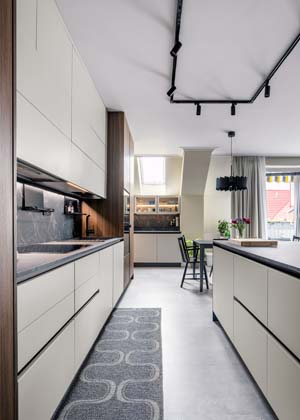 V prostorově velkorysé kuchyni je dostatek volných pracovních ploch i úložných míst. Několik typů svítidel včetně prosvětlení horních skříněk umožňuje v kuchyni měnit světelnou atmosféru.