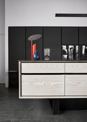 Dinesen, kuchyň v&nbsp;kontrastn&iacute;m proveden&iacute; ostrůvku z&nbsp;př&iacute;rodn&iacute;ho dřeva s&nbsp;deskou z&nbsp;nerezavěj&iacute;c&iacute; oceli a&nbsp;bloku vysok&yacute;ch skř&iacute;n&iacute; s&nbsp;povrchem z&nbsp;matn&eacute;ho čern&eacute;ho linolea