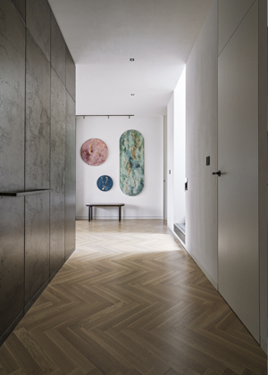 Design&eacute;ři se rozhodli nav&aacute;zat na uměleck&eacute; c&iacute;těn&iacute; majitelů pojet&iacute;m bytu jako snov&eacute; krajiny, kterou ve vstupn&iacute; hale otev&iacute;raj&iacute; pl&aacute;tna od Aliny Shupikovov&eacute;.